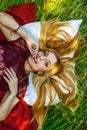 Portrait of a beautiful young blonde girl resting in nature. Girl lying in a field on the grass and smiling. in the hands of the g Royalty Free Stock Photo