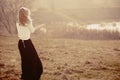 Portrait of a beautiful young blonde girl in the white pullovers, standing with his back