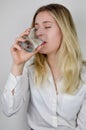 Portrait of a beautiful young blonde woman drinking a glass of water Royalty Free Stock Photo