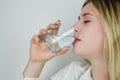 Portrait of a beautiful young blonde woman drinking a glass of water Royalty Free Stock Photo