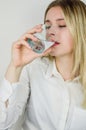 Portrait of a beautiful young blonde woman drinking a glass of water Royalty Free Stock Photo