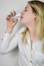 Portrait of a beautiful young blonde woman drinking a glass of water Royalty Free Stock Photo