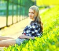 Portrait of beautiful young blonde woman lying on the grass in summer park Royalty Free Stock Photo