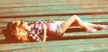 Portrait of beautiful young blonde woman lying relaxing on the bench in summer park Royalty Free Stock Photo