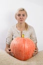 Portrait of beautiful young blonde woman with pumpkin ready for halloween celebration, mockup for postcard and invitation or adver