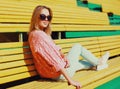 Portrait beautiful young blonde woman sitting on bench in a city park Royalty Free Stock Photo