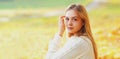 Portrait of beautiful young blonde woman in sunny autumn