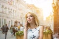 Portrait of beautiful young blonde woman talking on mobile phone on the city street. Royalty Free Stock Photo