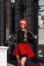 Portrait of beautiful young blonde woman wearing stylish black outfit, she smiling on urban background Royalty Free Stock Photo