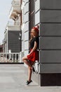 Portrait of beautiful young blonde woman wearing stylish black outfit, she smiling on urban background Royalty Free Stock Photo