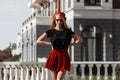 Portrait of beautiful young blonde woman wearing stylish black outfit, she smiling on urban background Royalty Free Stock Photo