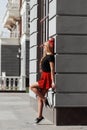 Portrait of beautiful young blonde woman wearing stylish black outfit, she smiling on urban background Royalty Free Stock Photo