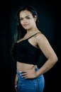 Portrait of a beautiful young Brazilian woman with one hand on her hip, dressed in jeans and a black top Royalty Free Stock Photo