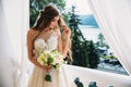 Portrait of beautiful young bride with cute smite in white wedding dress hold bouquet of flowers in her hands. Concept Royalty Free Stock Photo