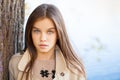 Portrait of a beautiful brunette little girl, autumn park outdoors