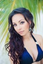 Portrait of a beautiful young brunette woman with long curly hair against a background of exotic nature Royalty Free Stock Photo