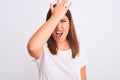 Portrait of beautiful and young brunette woman standing over isolated white background surprised with hand on head for mistake, Royalty Free Stock Photo