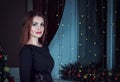 Portrait of beautiful young brunette woman standing in a room decorated for New Year Royalty Free Stock Photo
