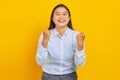 Portrait of beautiful young business woman with confident face excited and celebrating success on yellow background Royalty Free Stock Photo