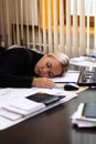 Portrait of a beautiful young business woman sleeping at her workplace in the office. Royalty Free Stock Photo