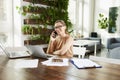 Attractive businesswoman making a call while sitting in front of laptop in the office and working Royalty Free Stock Photo