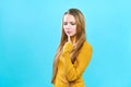 Portrait of a beautiful young caucasian female student with long blond hair. In a yellow sweater. Girl, puzzled. Royalty Free Stock Photo