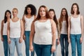 Portrait of beautiful young caucasian plus size woman in white shirt looking at camera. Group of diverse women posing Royalty Free Stock Photo