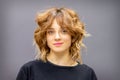 Portrait of a beautiful young caucasian red-haired woman with short wavy hairstyle smiling and looking at camera on dark Royalty Free Stock Photo