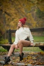 Portrait of a beautiful young Caucasian sensual woman with a red cap ,white pullover and black boots in autumn park Royalty Free Stock Photo