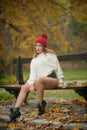 Portrait of a beautiful young Caucasian sensual woman with a red cap ,white pullover and black boots in autumn park Royalty Free Stock Photo
