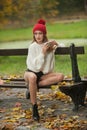 Portrait of a beautiful young Caucasian sensual woman with a red cap ,white pullover and black boots in autumn park Royalty Free Stock Photo