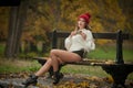 Portrait of a beautiful young Caucasian sensual woman with a red cap ,white pullover and black boots in autumn park Royalty Free Stock Photo