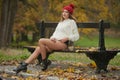 Portrait of a beautiful young Caucasian sensual woman with a red cap ,white pullover and black boots in autumn park Royalty Free Stock Photo