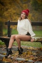 Portrait of a beautiful young Caucasian sensual woman with a red cap ,white pullover and black boots in autumn park Royalty Free Stock Photo