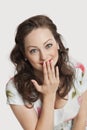 Portrait of beautiful young Caucasian woman smiling with hand over mouth against white background Royalty Free Stock Photo