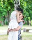 Portrait of beautiful young couple female bride and male bridegroom kissing in summer park. Man husband holding woman wife in his Royalty Free Stock Photo