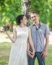 Portrait of beautiful young couple female bride with small wedding pink flowers roses bouquet and male bridegroom holding hands, s Royalty Free Stock Photo