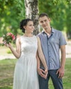 Portrait of beautiful young couple female bride with small wedding pink flowers roses bouquet and male bridegroom standing and hol Royalty Free Stock Photo