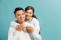 Portrait of beautiful young couple hugging, looking at camera and smiling, isolated on blue Royalty Free Stock Photo