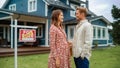 Portrait of a Beautiful Young Couple in Love Standing in Front Their New Home. Successful Homeowners Royalty Free Stock Photo