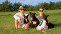 PORTRAIT: Beautiful young couple relaxes outdoors with their adorable dogs. Royalty Free Stock Photo