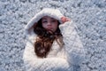 Portrait of beautiful, young, cute, brunette woman, freezing in the cold winter in white coat and hood, lying like standing Royalty Free Stock Photo