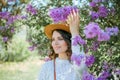 Portrait of beautiful young dark-haired woman with blue eyes in hat near the blooming. Happy model with curly hair. Spring Royalty Free Stock Photo