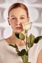 Portrait of a beautiful young disabled woman, born without an arm, holding a flower in her hands in a white dress Royalty Free Stock Photo