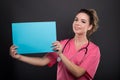 Portrait of beautiful young doctor holding blue cardboard