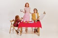 Portrait of beautiful young family having breakfast together isolated on grey background. Movie remake Royalty Free Stock Photo