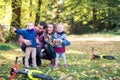 Beautiful young family with small twins on a walk in autumn forest, resting. Royalty Free Stock Photo