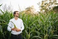 Portrait of a beautiful young farmer (student) working in the field, happy, in a shirt, corn field. Concept