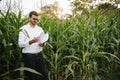 Portrait of a beautiful young farmer (student) working in the field, happy, in a shirt, corn field. Concept