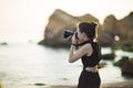 Portrait of beautiful young female tourist photographer with camera at sea Royalty Free Stock Photo